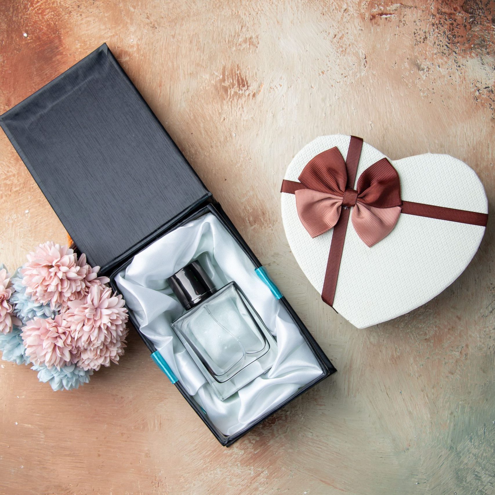 top-view-men-cologne-box-heart-shaped-box-flowers-table-min